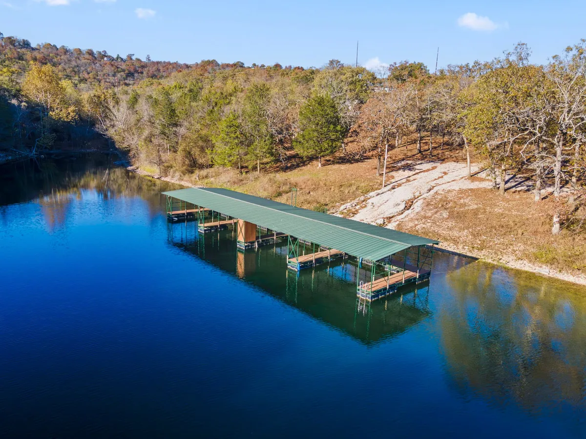 A serene boat dock stretches over calm water, framed by lush trees. The tranquil setting is perfect for boating, fishing, or simply relaxing by the water’s edge, inviting guests to embark on outdoor adventures.