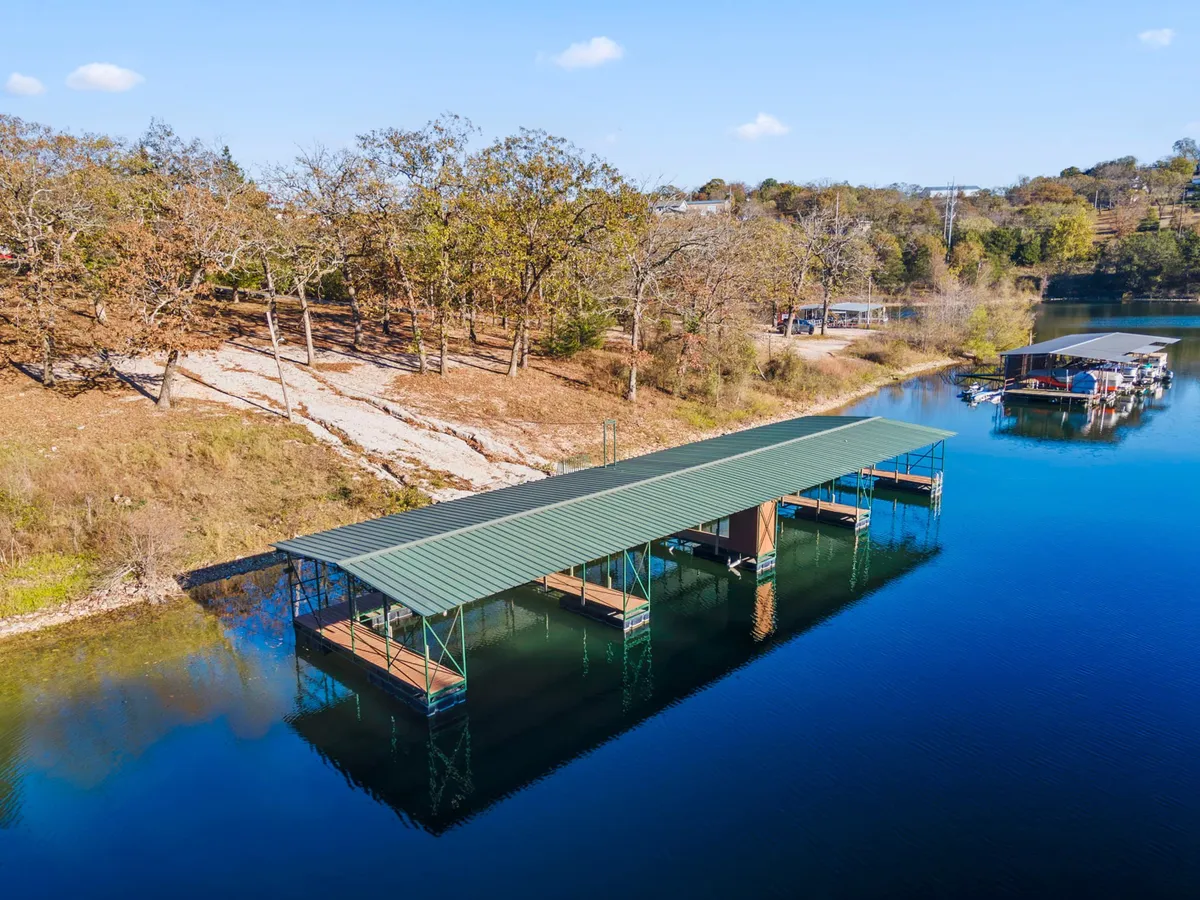 A peaceful dock extending into calm water, surrounded by trees. The scene is tranquil and inviting, ideal for early morning fishing trips or launching a boat for a day of adventure.